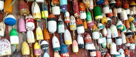 Téléchargez les photos : Une collection de flotteurs en liège marin colorés suspendus sur un mur - en image libre de droit