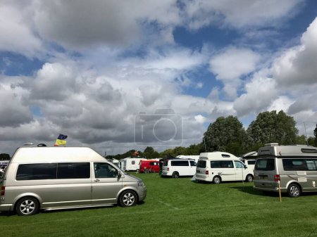 Foto de VW Campervams aparcado bajo un cielo azul y nublado en un camping festival. Cambridge, Reino Unido, 5 de agosto de 2017. - Imagen libre de derechos