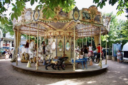 Téléchargez les photos : Carrousel français traditionnel à l'ombre des arbres. Vichy, France, le 16 août 2012. - en image libre de droit