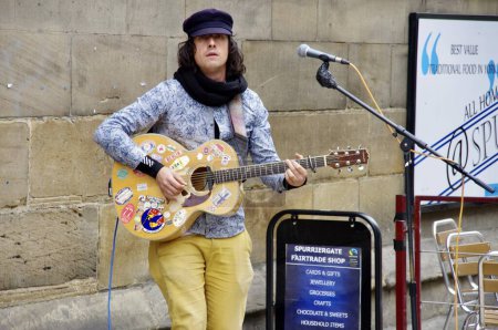 Foto de Un busker masculino tocando la guitarra en Spurriergate. York, Reino Unido, 4 de junio de 2012. - Imagen libre de derechos