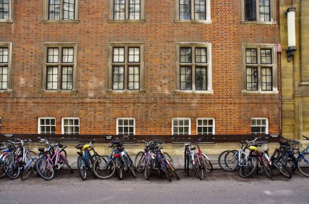 Foto de Una fila de bicicletas con edificio de ladrillo rojo detrás. - Imagen libre de derechos