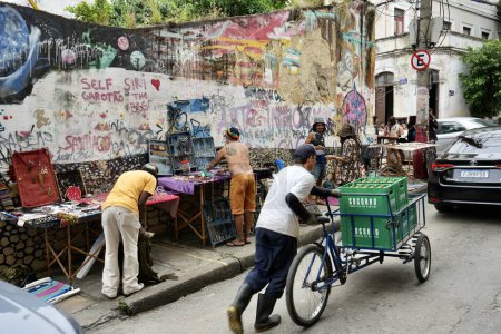 Photo for Street sellers in Lapa close to the Selaron Steps, with colourful street art behind. Rio de Janeiro, Brazil, October 27, 2023. - Royalty Free Image