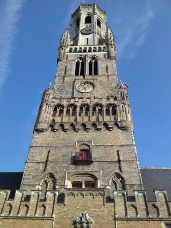 Photo for The Belfry of Bruges tower under a blue sky. Medieval bell tower on the Grand Place. Bruges, Belgium, August 9, 2009. - Royalty Free Image