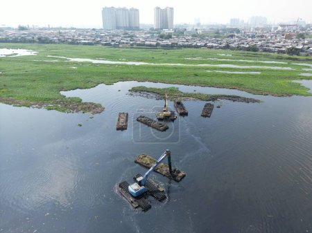 Téléchargez les photos : Dragage du lac au milieu de la ville qui a beaucoup de boue en elle et l'eau est devenue noire - en image libre de droit