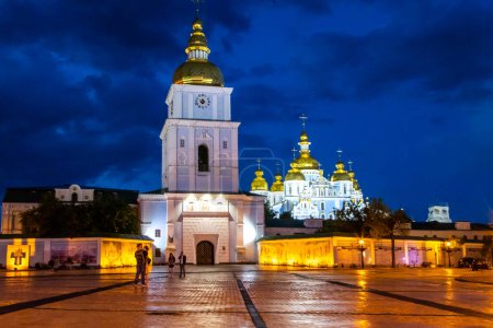 Photo for St. Michaels Golden Domed Monastery, Kiev Ukraine. High quality photo, seen in blue hour twilight with a dramatic cloudy sky and golden ligt from the lanterns on the square in front of the monastery - Royalty Free Image