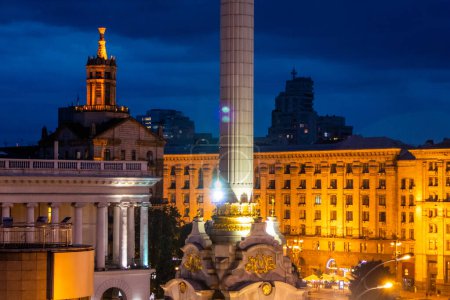 Foto de La plaza europea en Kiev, Ucrania antes de la guerra, Majdan Nezalezjnosti. Foto de alta calidad con luz que se desvanece en la noche de hora azul. Las luces de la calle y los coches son visibles, la luz ilumina las estatuas - Imagen libre de derechos