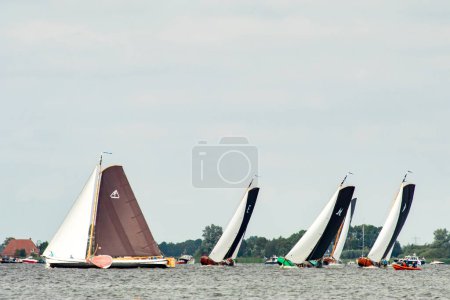 Photo for Traditional sailing boats racing on the Sneekermeer, Friesland. Wooden, flat bottomed, historic sailboats called skutsjes racing on a Frisian Lake near Sneek. High quality photo - Royalty Free Image