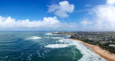 Photo for Aerial image of Dicky Beach, Australia, wild surf on golden beach. Residential area behind the coastline. Blue sky with fluffy white clouds. High quality photo - Royalty Free Image