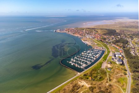 Aerial drone image of Terschelling and the Wadden sea on a summer day. Low tide shows the sandbanks and shallows of the Wadden sea. Marina and West-Terschelling and dunes visible. High quality photo