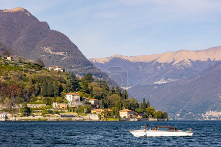 Téléchargez les photos : Lago di Como, Lac de Côme, Italie, avec Palacios, grandes maisons au printemps. Watertaxi, Riva, bateau typiquement italien. Ciel bleu et couleurs vives. Photo de haute qualité - en image libre de droit