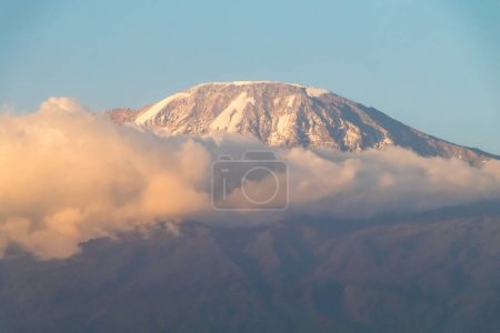 Photo for Mount Kilimanjaro seen through clouds with foreground bush. Top covered in Snow, dramatic mood. High quality photo - Royalty Free Image