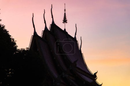Photo for Details of a roof a Buddhist Temple during pink, vibrant and colourful sunset, Thailand. High quality photo - Royalty Free Image