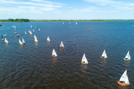 Téléchargez les photos : Image de drone d'un lac, le Sneekermeer, à Sneek, Frise, Pays-Bas avec de nombreux petits voiliers. Ouvrez des voiliers en bois colorés dans une course. Photo de haute qualité - en image libre de droit