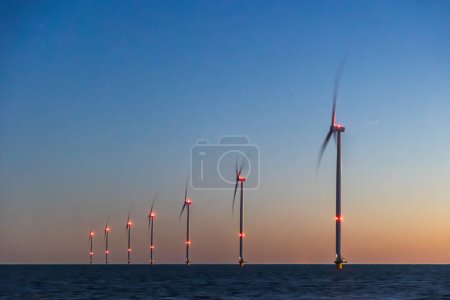 Foto de Turbinas eólicas en alta mar o molinos de viento en el mar al atardecer azul o de noche, larga exposición y estrellas visibles. Foto de alta calidad - Imagen libre de derechos