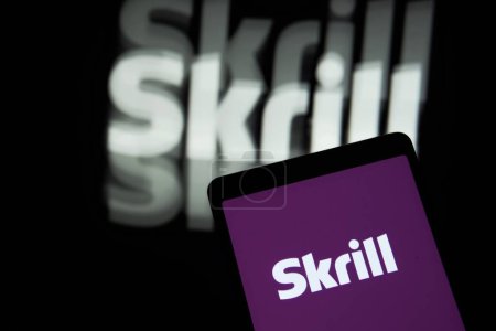 Photo for Dhaka, Bangladesh - Jun 29, 2023: Skrill logo of a financial technology company is seen on a mobile phone and a computer screen. - Royalty Free Image