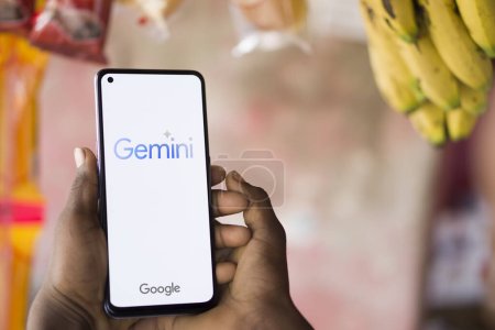 Foto per Dhaka, Bangladesh - 27 dicembre 2023: Mano in mano un telefono cellulare con Google Gemini AI chatbot Gemini è una famiglia di modelli multimodali di grande lingua sviluppati da Google. - Immagine Royalty Free