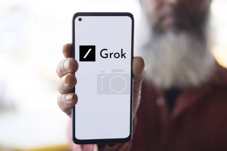 Téléchargez les photos : Dacca, Bangladesh - 28 décembre 2023 : Main tenant un téléphone avec un chatbot Grok AI. Grok est une start-up américaine travaillant dans le domaine de l'intelligence artificielle, fondée par Elon Musk. - en image libre de droit