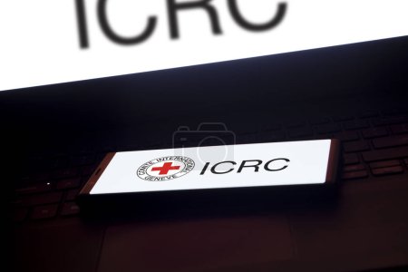 Foto de Dhaka, Bangladesh - 19 de enero de 2024: logotipo del CICR en el teléfono inteligente y la computadora portátil de fondo. El Comité Internacional de la Cruz Roja es una organización humanitaria. - Imagen libre de derechos