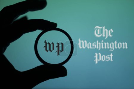 Téléchargez les photos : Dacca, Bangladesh - 26 janvier 2024 : Une personne tenant une loupe pour inspecter le logo du Washington Post. Le Washington Post est un quotidien américain. - en image libre de droit