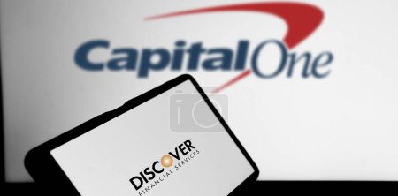 Photo for Dhaka, Bangladesh- 22 February 2024: Discover Financial Services logo is displayed on a smartphone and the Capital One Financial logo on the background. - Royalty Free Image