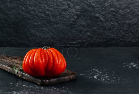 Téléchargez les photos : Trois frais Raf Coeur De Boeuf tomate, fond sombre, concept rustique, espace pour le texte, photo de la réserve - en image libre de droit