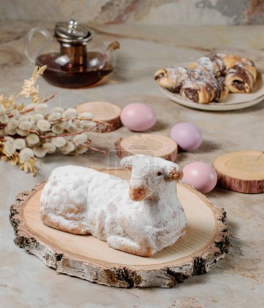 Easter sweet lamb cake, eggs, willow, tea and wood on old vintage background
