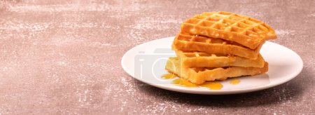 Téléchargez les photos : Delicious Belgian waffles with honey served on white plate and brown background, rustic concept, space for text - en image libre de droit