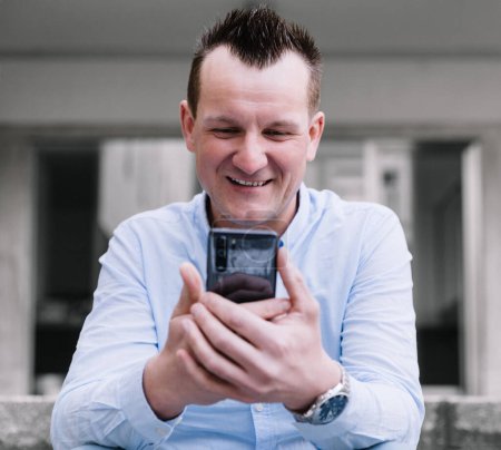 Téléchargez les photos : Un homme d'affaires confiant avec un smartphone dans la ville. Vision d'entreprise, communications, achats en ligne - en image libre de droit