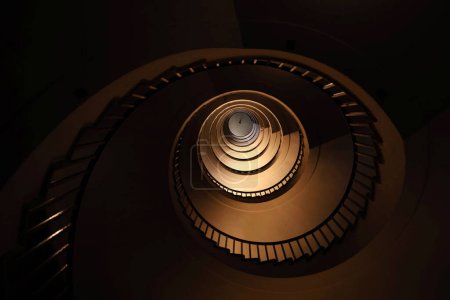 Photo for Spiral staircase in a tall multi-floor house, in the form of a " - Royalty Free Image