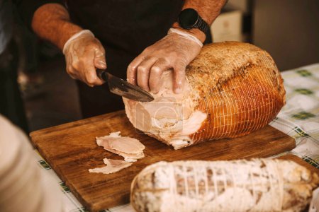 Photo for Artisan Chef Carving Slices from a Whole Roasted Ham - Royalty Free Image