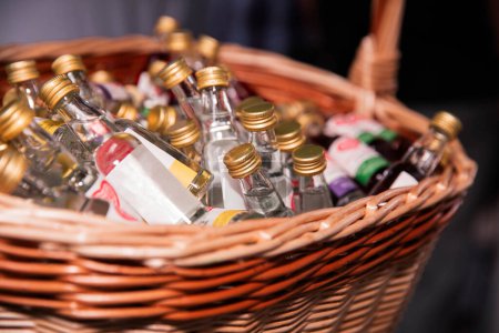 A variety of small liquor bottles displayed in a basket