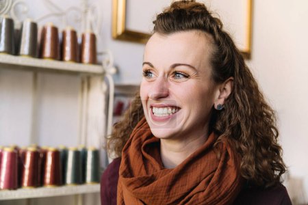 Eine Frau mit ausdrucksstarken blauen Augen und lockigem Haar lacht, Ladenkonzept