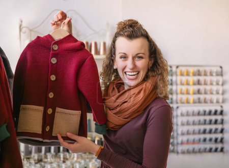 Frau mit lockigem Haar und modischer roter Jacke steht in einer Boutique