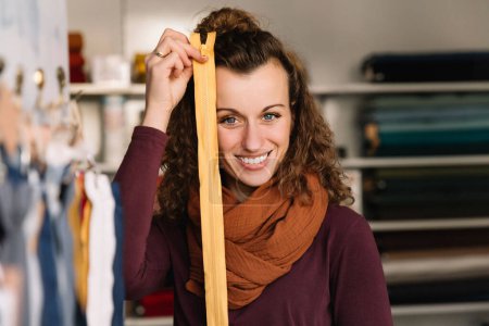 Charmante Modedesignerin mit Reißverschluss in ihrem Kreativladen