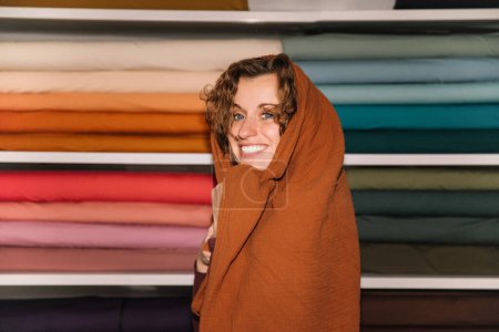 Verspielte Modedesignerin in warmes Textilgeschäft gehüllt
