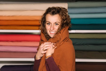 Diseñador de moda envuelto en calidez y creatividad en la tienda de estudio textil