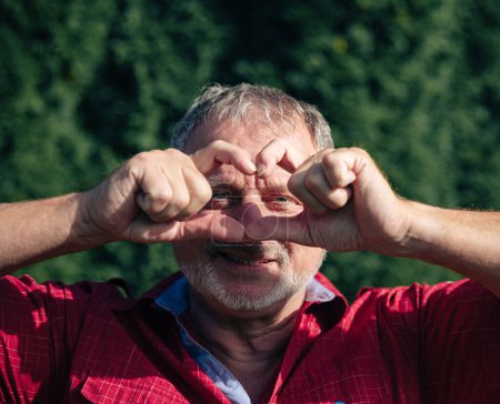 Man in red shirt making heart sign with hands