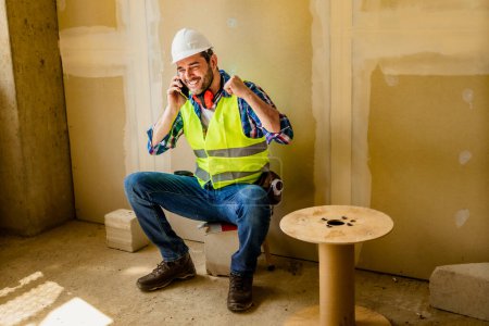 Builder or contractor using a mobile phone on construction site.