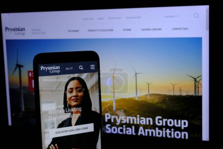Foto de En primer plano, el sitio web del Grupo Prysmian visto en un teléfono móvil y en segundo plano una página del sitio web de la empresa que cotiza en la Bolsa de Milán. - Imagen libre de derechos
