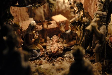Niño Jesús en el pesebre con la Virgen y San José, en el fondo el burro y el buey. Alrededor de los Reyes Magos y otros personajes de la cuna de estilo "napolitano".