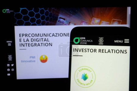 Téléchargez les photos : Au premier plan d'un smartphone, le logo d'EPR Comunicazione spa, une société cotée à la Bourse de Milan dans le segment Euronext Growth Milan. Le tic-tac est EPRB. La société s'occupe des campagnes de communication. - en image libre de droit
