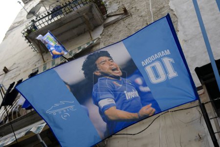 Foto de Banderas con fotos de Diego Armando Maradona exultante, exhibido desde un balcón en el corazón de Nápoles. - Imagen libre de derechos
