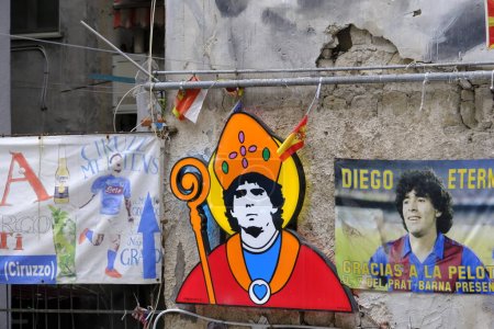Foto de Diego Armando Maradona vestido como San Gennaro, el santo patrón de la ciudad de Nápoles. Obra artística colocada en Largo Maradona en los barrios españoles de Nápoles. - Imagen libre de derechos