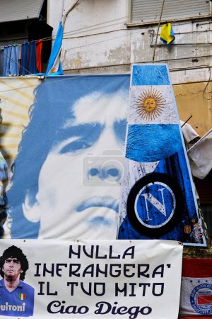 Foto de El logotipo de Napoli, la bandera de Argentina y la cara de Maradona impresa en algunas pancartas. La inscripción dice: 'Nada romperá tu mito. Hola Diego. Estamos en Largo Maradona en Nápoles. - Imagen libre de derechos