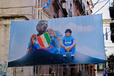 Foto de Banner con la imagen de Víctor Osimhen mostrando el tercer scudetto ganado por Napoli y junto a él Diego Armando Maradona sentado junto al Vesubio. - Imagen libre de derechos