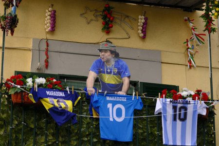 Foto de Un balcón en los barrios españoles de Nápoles, con la figura de Maradona y unas camisas número 10 usadas por el gran futbolista argentino. - Imagen libre de derechos