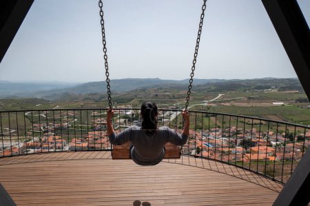 Foto de Mujer en un momento relajado montando un columpio en el mirador de Vila Flor Nabo, Tras os Montes, Portugal - Imagen libre de derechos