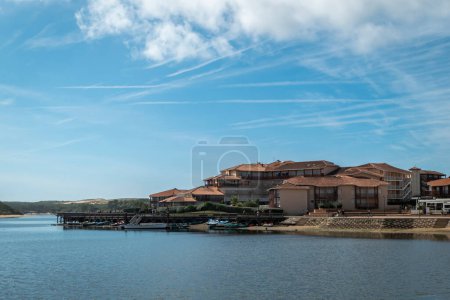 Téléchargez les photos : Vue panoramique sur la plage et une partie de la ville à Vieux Boucau les Bains au Pays Basque avec une petite jetée et quelques bateaux sur l'eau en France par une journée nuageuse - en image libre de droit