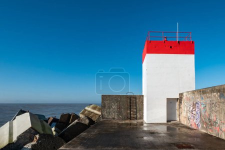 Photo for Dike on the beach of the Digue in Boucau in the Basque Country in France, with a lighthouse in front - Royalty Free Image