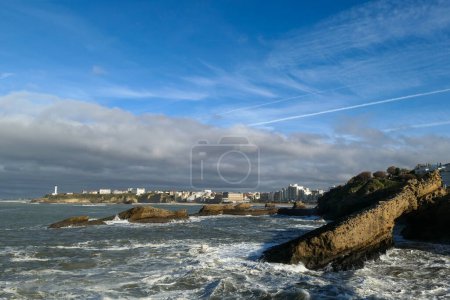 Foto de Vista panorámica de parte de la ciudad de Biarritz, con la playa y algunas rocas en frente y un fuerte oleaje de mar - Imagen libre de derechos